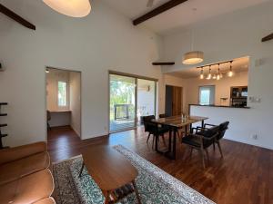 an open living room with a table and chairs at うふた in Tatsugo