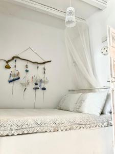 a bedroom with a bed with a curtain and various items on the wall at LemonStello Kythnos in Dhriopís