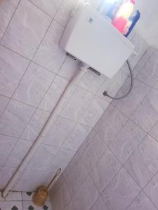 un pavimento piastrellato bianco con servizi igienici in bagno. di Welcominghome a Ishaka