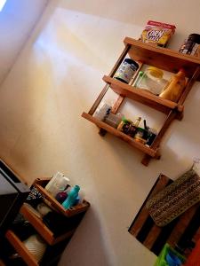 Welcominghome في Ishaka: غرفة مع رفوف خشبية على الحائط