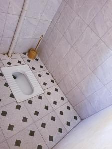 een badkamer met een toilet op een tegelvloer bij Welcominghome in Ishaka