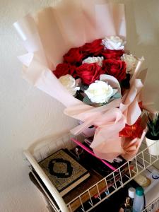 a bouquet of red roses in a box on a shelf at Welcominghome in Ishaka