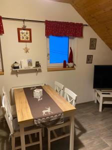 uma sala de jantar com uma mesa de madeira e cadeiras em Apartman U vleku em Ceske Petrovice
