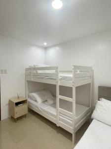 a bedroom with two bunk beds and a night stand at Chan One Corner in San Juan