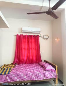 1 cama con cortina roja en una habitación en KG Homes, en Chidambaram