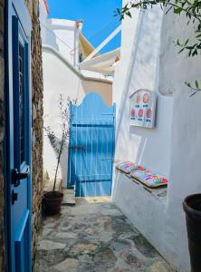 a blue gate in a alley with a blue door at LemonStello Kythnos in Dhriopís