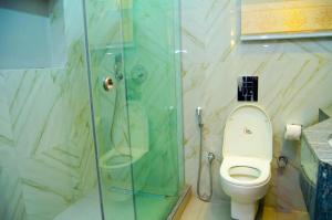 a bathroom with a toilet and a glass shower at Luxury Oasis 1 - Entire 1 Bedroom Apartment in Abuja with Pool, Games, WiFi, Balcony, and Garden in Abuja