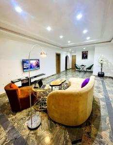 a living room with two couches and a table at Luxury Oasis 1 - Entire 1 Bedroom Apartment in Abuja with Pool, Games, WiFi, Balcony, and Garden in Abuja