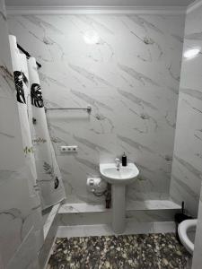 Baño blanco con lavabo y aseo en На Майлина en Turksib