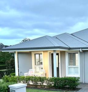a house with a blue roof with two chairs at Guest house in Harrington Park in Narellan