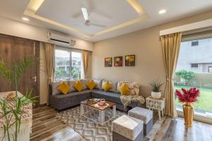 Alaya Heaven in Hills Luxe 2BHK Villa with Pvt Pool, Udaipur في أودايبور: غرفة معيشة مع أريكة وطاولة