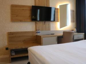 a hotel room with a bed and a desk with a tv at Isnova Hotel in Antalya