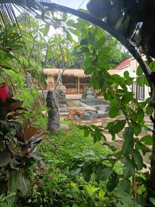 un jardín con un edificio de fondo en BAMBOO OASIS, en Ubud