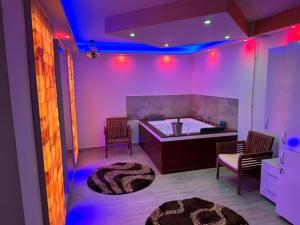 a room with purple lights and a kitchen with a rug at Casa Hanea & SPA piscina exterioara incalzita ,sauna, jacuzzi privat in fiecare apartament in Sibiu