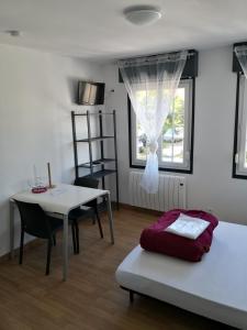 una habitación con una cama y una mesa y una ventana en Tout à pied - 2 pers - 2 studios indépendants B et C, en Berck-sur-Mer