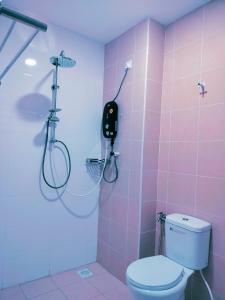 La salle de bains rose est pourvue d'une douche et de toilettes. dans l'établissement JOY SITIAWAN HOMESTAY, à Sitiawan