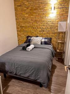 Bett in einem Zimmer mit Ziegelwand in der Unterkunft Heart of the City: Cozy 2-Bed Loft in Winnipeg