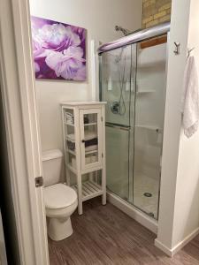 a bathroom with a toilet and a glass shower at Heart of the City: Cozy 2-Bed Loft in Winnipeg