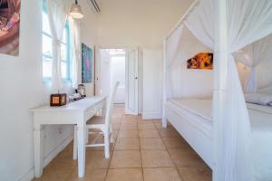 a white bedroom with a desk and a bed at Scuba Seraya Resort in Tulamben