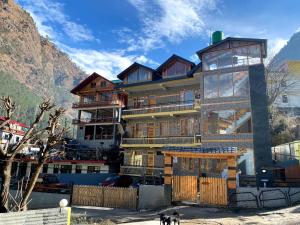 a large building with a dog standing in front of it at Dhi Ananta Homestay - Pure Veg in Kasol