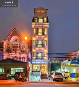 um edifício alto com uma torre de relógio à noite em HANZ Gia Hoang Hotel em Da Lat