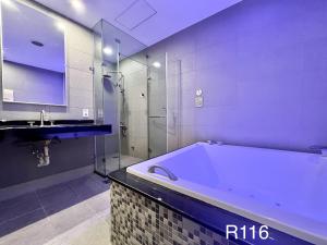 uma grande casa de banho com banheira e lavatório em Catwalk Motel -Tainan em Tainan