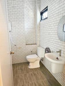ein weißes Bad mit einem WC und einem Waschbecken in der Unterkunft Vamin Poolvilla Chiangkhan Loei วามินทร์พูลวิลล่า เชียงคาน เลย - วามินทร์ รีสอร์ท in Chiang Khan