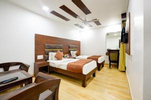 a hotel room with two beds and a desk at Staybook South Delhi in New Delhi