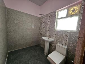 a bathroom with a sink and a toilet and a window at homeystay urbandream in Faridabad