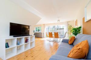 a living room with a blue couch and a flat screen tv at 4-bedhaven In Fawley Perfect For Extendedstays! in Totton