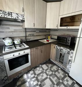 a kitchen with wooden cabinets and a stove top oven at Ахметова 12 in Almaty