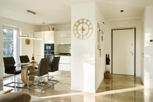 a kitchen and dining room with a table and a clock at SalvatoreHomes - Luxury Villa with private Dream Garden & BBQ - Casa Palma - a 5 Star Luxury Collection at Lake Garda in San Zeno di Montagna +21 photos