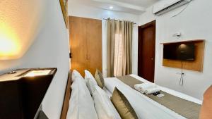 a bedroom with a bed with a tv on the wall at Aura Luxury Studio Near Golf Course Road, Sector 57, Gurgaon in Gurgaon