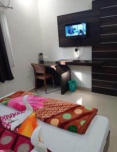 a room with a bed with a desk and a television at Hotel City inn in Gaya