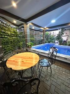 a patio with a table and chairs and a swimming pool at Sts. Joachim and Ann Staycation house in Ulot