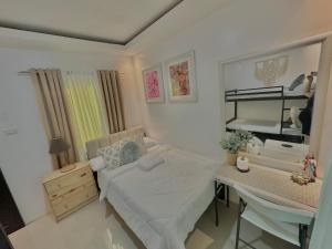 a small bedroom with a bed and a desk at Sts. Joachim and Ann Staycation house in Ulot