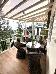 a patio with a table and chairs on a deck at Sts. Joachim and Ann Staycation house in Ulot