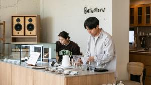 a man and woman standing at a counter in a kitchen at Jimi Stay in Jeju