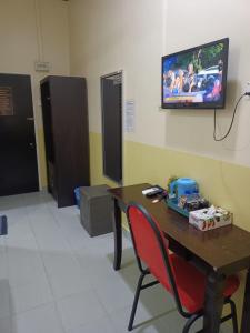 a room with a table and a tv on the wall at Alia Express Seri Ibai Permai in Kuala Terengganu