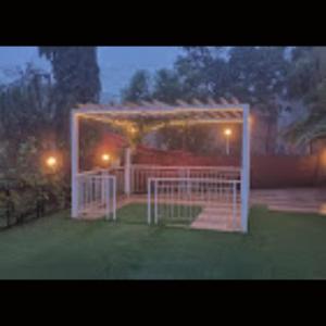 a gazebo with a gate in the yard at night at Strawberry County in Panchgani