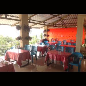 a restaurant with tables and chairs with red table cloth at Strawberry County in Panchgani