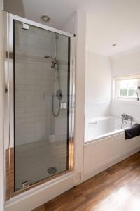 a shower in a bathroom with a bath tub at Spilfeathers Cottage in Freyerning