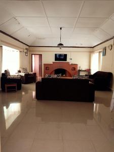 uma sala de estar com sofás pretos e uma lareira em NICK'S AND ESSY'S PLACE em Juja