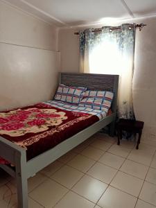 um quarto com uma cama em um quarto com janela em NICK'S AND ESSY'S PLACE em Juja