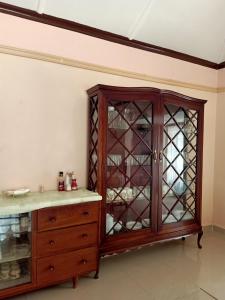 um armário de madeira com portas de vidro num quarto em NICK'S AND ESSY'S PLACE em Juja