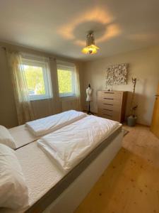 a bedroom with a large white bed and a dresser at City Apartment Markdorf in Markdorf