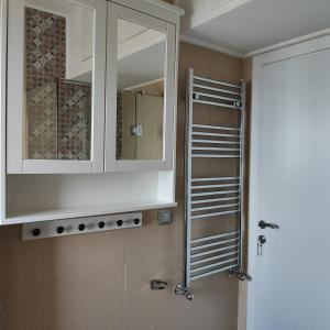 łazienka z białą szafką i lustrem w obiekcie Christina-2 w mieście Perea