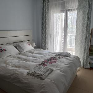 uma cama branca com flores e uma janela em Christina-2 em Perea