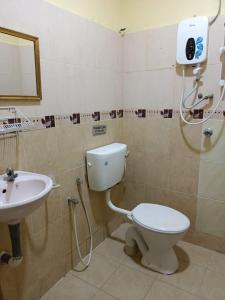 a bathroom with a toilet and a sink at Alia Express Seri Ibai Permai in Kuala Terengganu