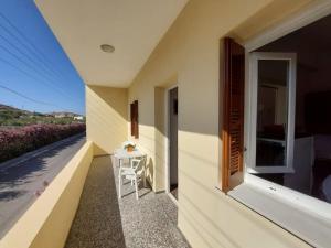 a balcony of a house with a table and a window at Ioanna's House@Foinikas Syros in Finikas